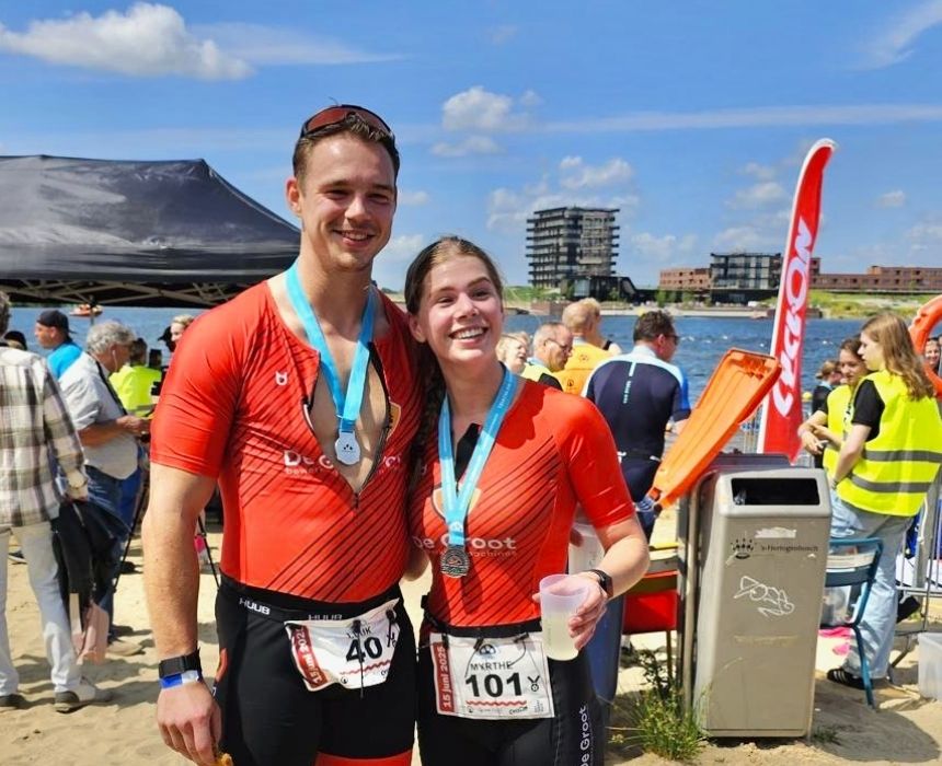 Twee collega's staan bij finish in De Groot kleding