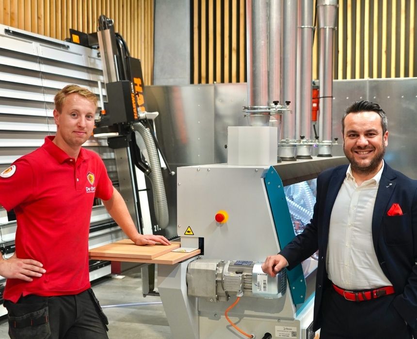 Servicetechnicus staat samen met accountmanager bij houtbewerkingsmachine in showroom