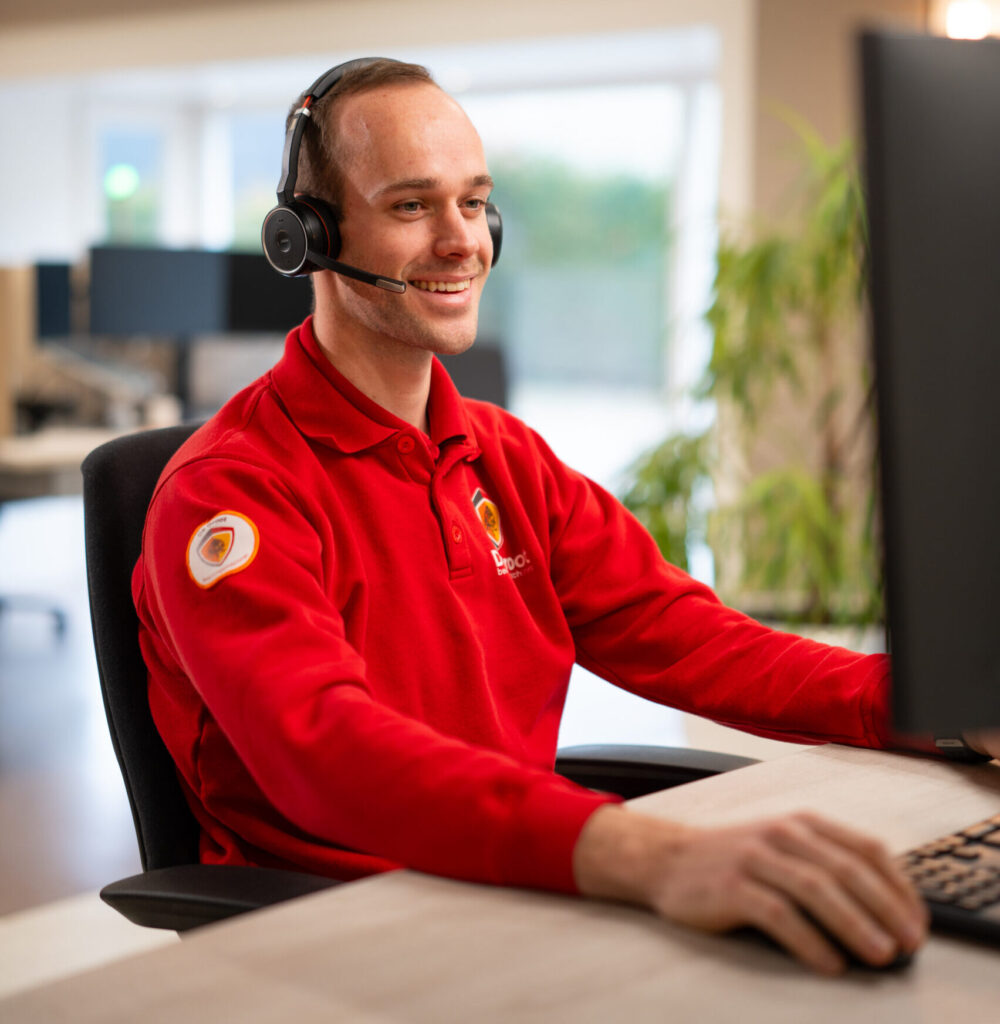 Servicecenter technicus kijkt vrolijk naar zijn laptop