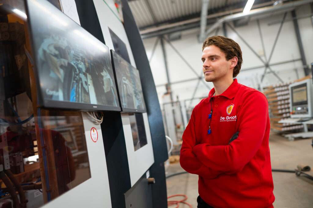Servicetechnicus kijkt tevreden naar de CNC-machine